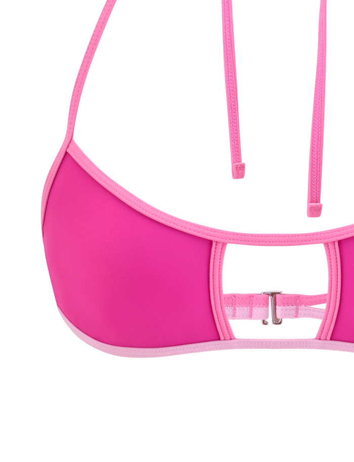 Close-up of the TIGERMIST PALMER BIKINI TOP - BERRY: a two-toned pink bikini top featuring a cutout, silver back clasp, thin adjustable halter straps, and light pink trim along the edges.