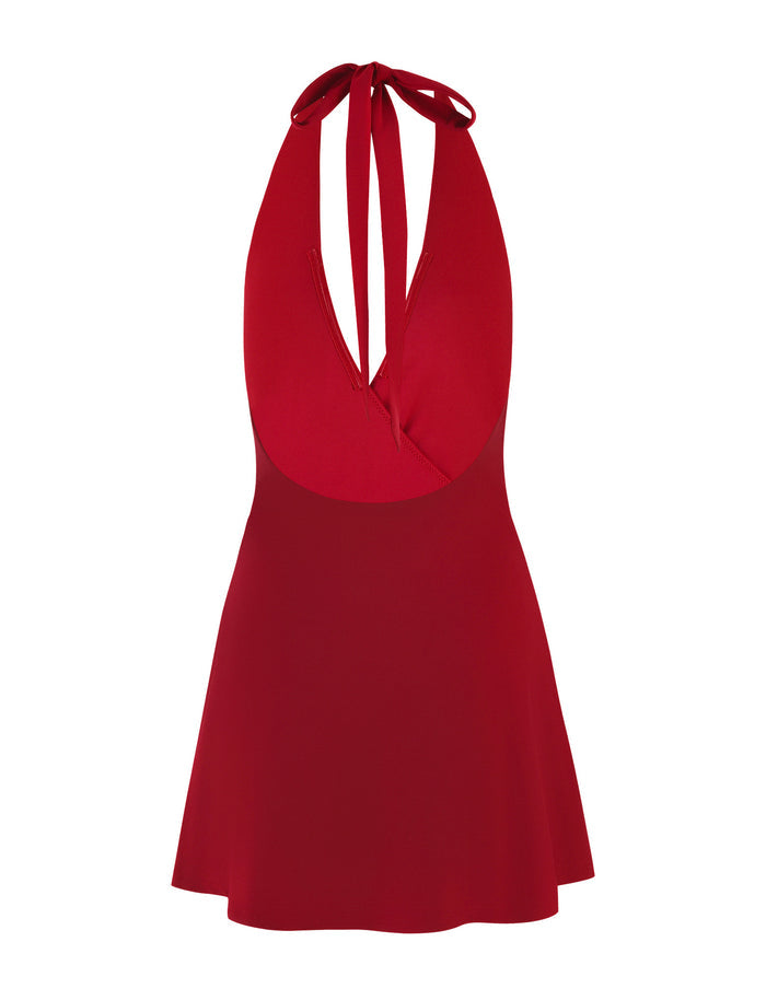 The PARRIS DRESS - RED by TIGERMIST is a vibrant red halter neck mini dress featuring a plunging neckline and a tie at the back. This sleeveless piece is fitted at the bodice, flaring into a short, A-line skirt with twist detailing at the hip. The fabric appears smooth and lightweight.