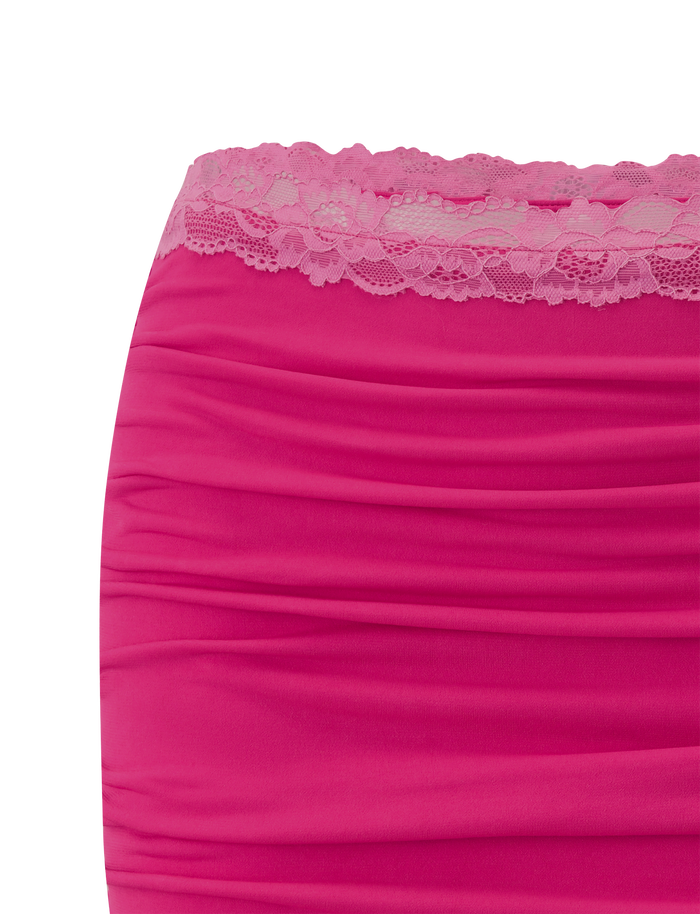 Close-up of the TIGERMIST PERSI MINI SKIRT in magenta, showcasing ruched fabric and a lace trim along the top edge.