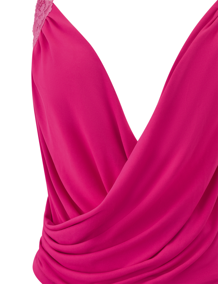 Close-up of the PERSI TOP in magenta by TIGERMIST, featuring a vibrant pink hue, draped cowl neck, sleeveless design, deep V-neckline, and delicate lace detailing on one shoulder.