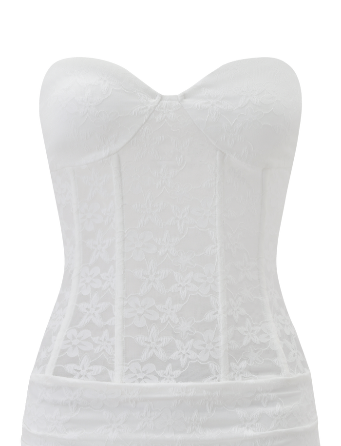 The TIGERMIST PETRA MINI DRESS in white lace features a strapless, corset-style bodice with floral patterns and structured boning, showcased elegantly against a plain white background.