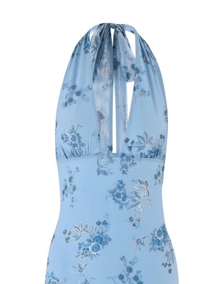 A close-up of the TIGERMIST PHAEDRA MAXI DRESS in blue floral, showcasing a halter neck, deep V-neckline, sheer fabric with silver accents, and a hint of a low open back for an elegant look.