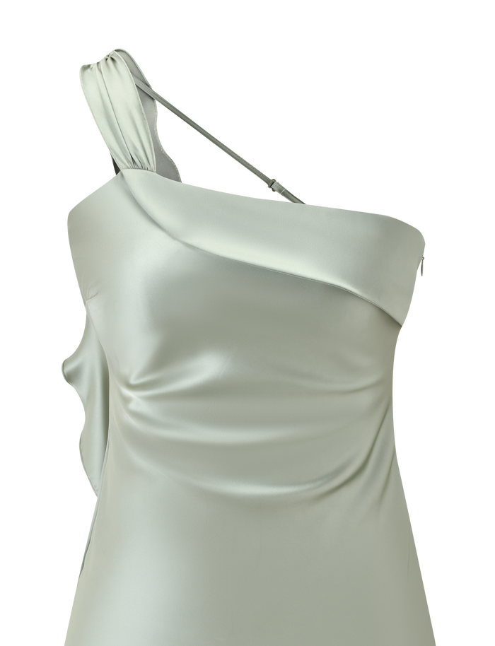 A close-up of the TIGERMIST RAINEY MINI DRESS in pistachio, featuring an asymmetric neckline, one thin strap, and a draped waterfall ruffle on one shoulder.