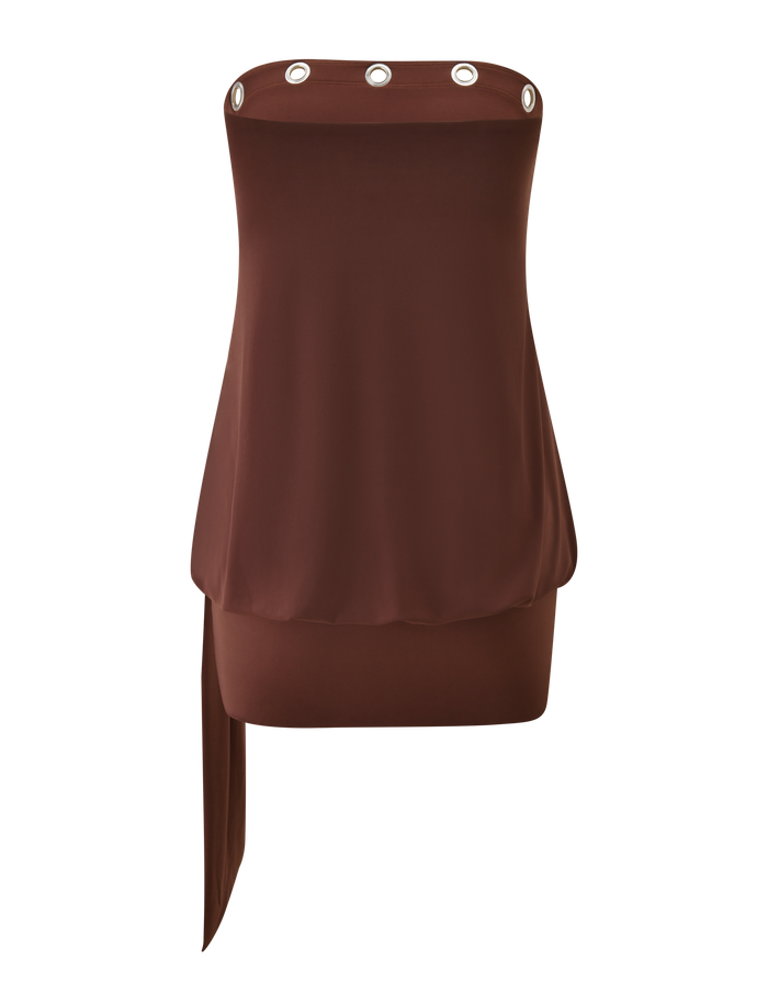 The RAVENNA DRESS - MILK CHOCOLATE by TIGERMIST is a strapless, bodycon mini dress with a drop waist skirt, silver eyelet trim on the top edge, and an asymmetrical draped panel.