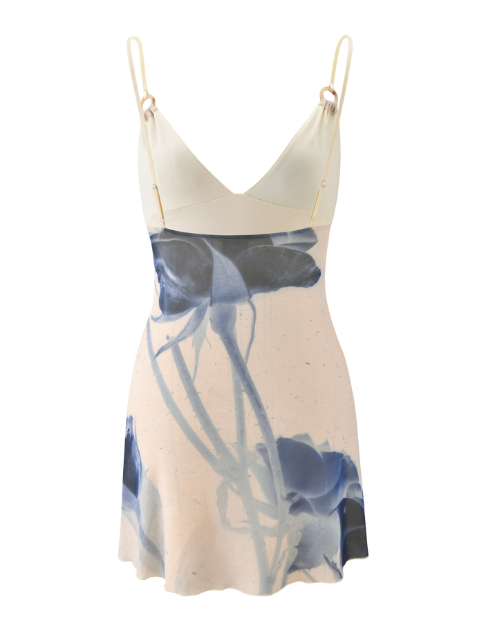 The TIGERMIST ROSY MINI DRESS - INDIGO FLORAL is a sleeveless mini dress with adjustable cami straps, a cream top, and a blue rose print skirt on a light background.