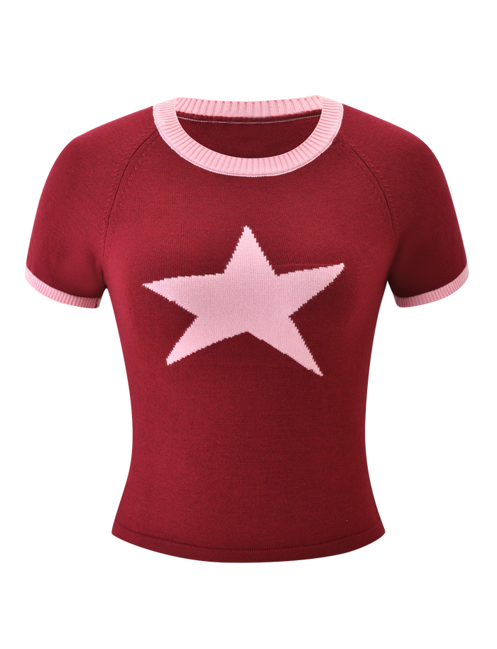 The ROUX TOP - RED by TIGERMIST is a fitted short-sleeve knit top with pink accents on the collar and sleeves and a large light pink asymmetrical star on the chest.