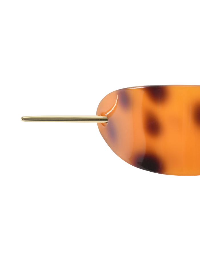 Close-up of the TIGERMIST RUKA BARRETTE - TORTOISESHELL, showcasing its chic oval acrylic design with a gold metal pin closure, set against a white background.
