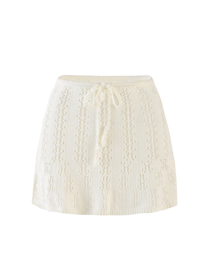 Introducing the SANDOR SKIRT in white from TIGERMIST, an above-the-knee design featuring a knitted, lace-like pattern. This stylish skirt includes a drawstring tie at the waist for an adjustable fit. The hem is slightly flared, lending it a soft and flowing appearance. Delicately textured with intricate details throughout, it's perfect for any occasion.