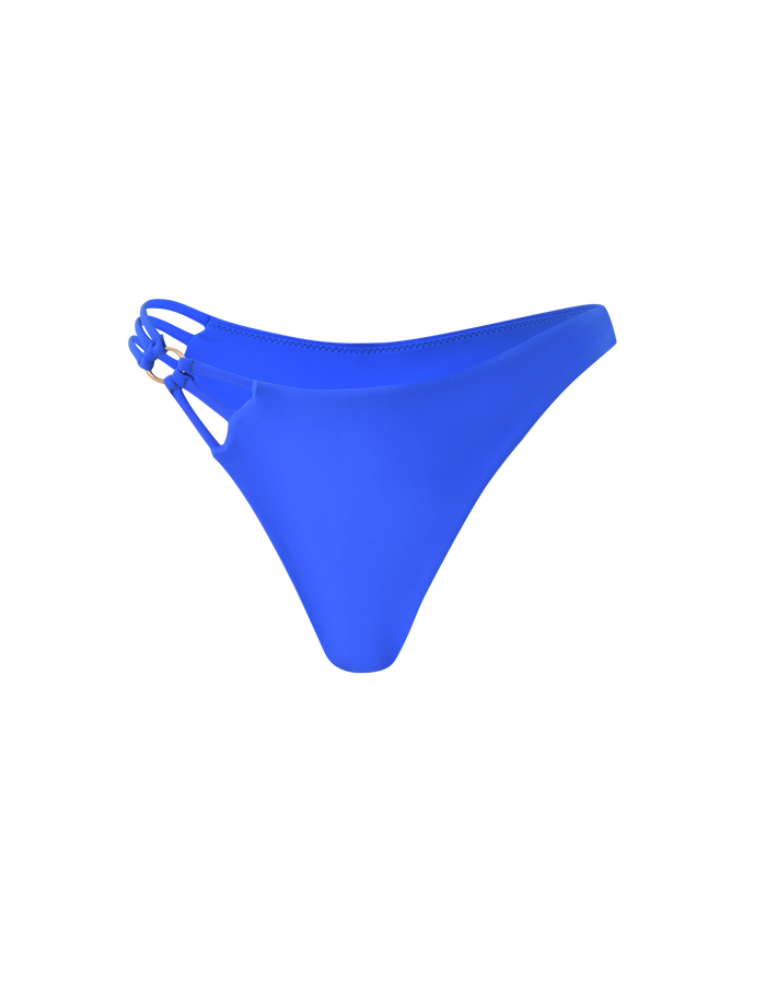 The TIGERMIST SHARLI BIKINI BOTTOM in cobalt blue features a cheeky cut, double side straps on the left, and a cut-out detail, shown against a plain white background.