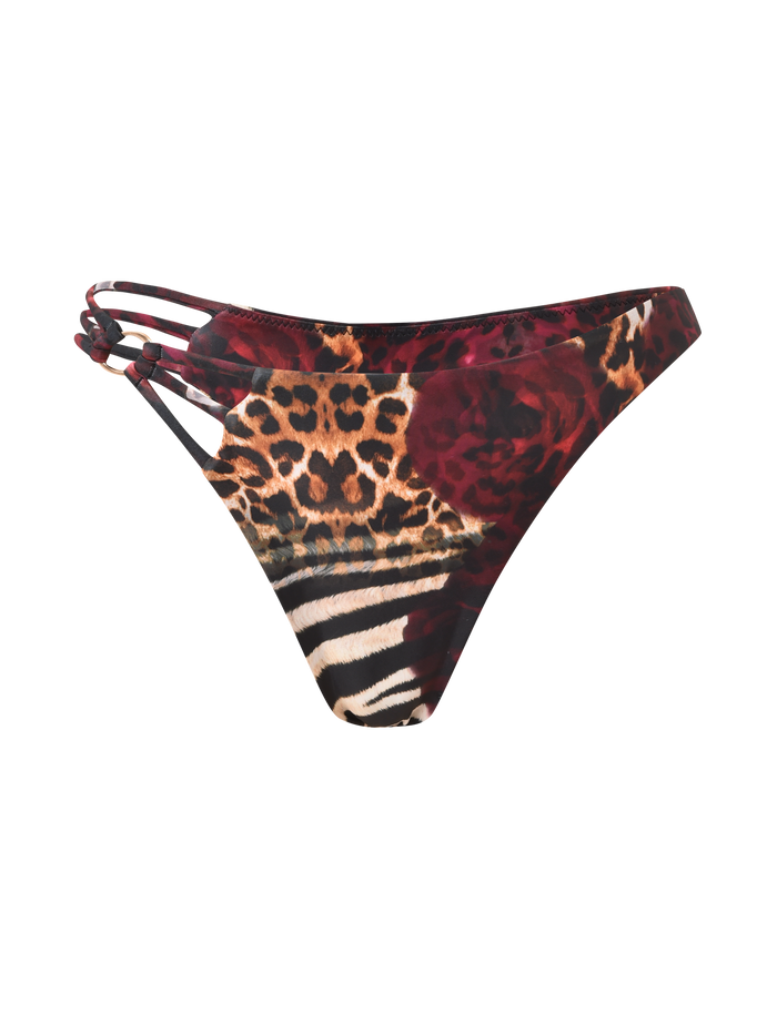 The SHARLI BIKINI BOTTOM by TIGERMIST features a mixed animal print with multicolored leopard spots, zebra stripes, maroon florals, exclusive swimwear details, and three thin side straps on the left.