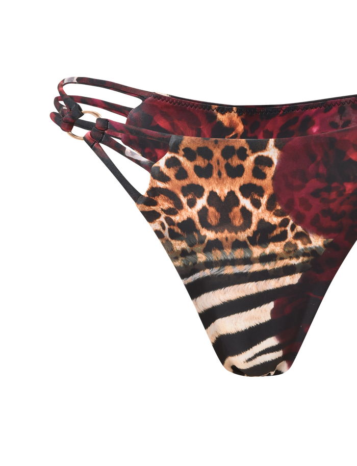 Close-up of the TIGERMIST SHARLI BIKINI BOTTOM - MIXED ANIMAL PRINT, featuring exclusive leopard and zebra patterns, floral details, and three thin side straps on one side, set against a plain background.