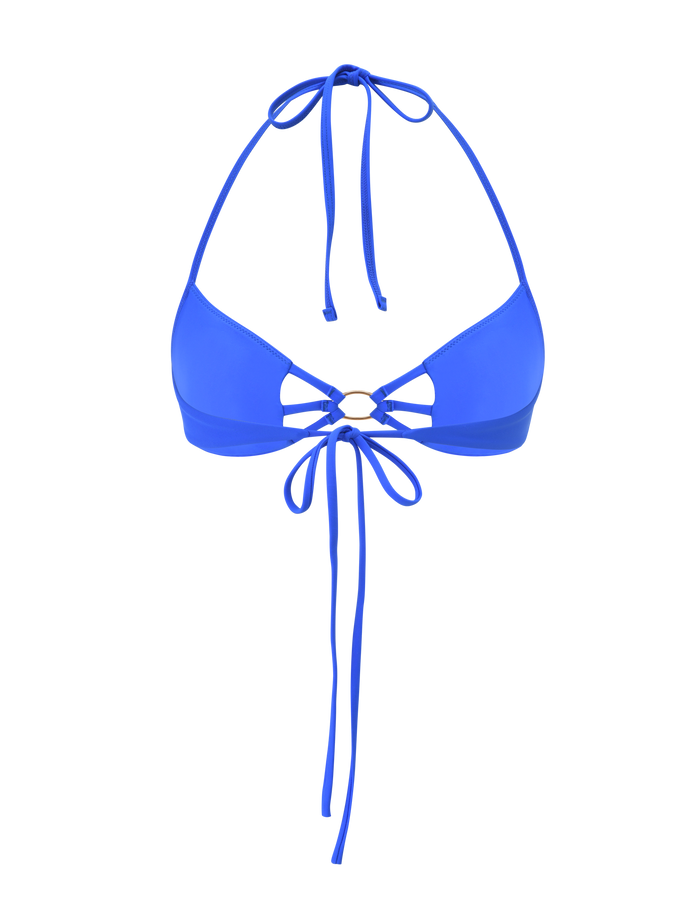 The SHARLI BIKINI TOP by TIGERMIST features a bright cobalt blue hue, halter neck and back ties, a central gold ring connecting the cups, and extra crisscross string details.