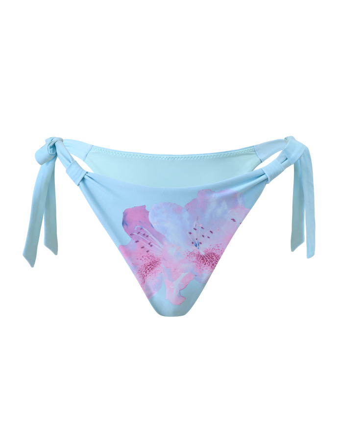 The SID BIKINI BOTTOM - BLUE by TIGERMIST features a light blue shade, adjustable side ties, and a striking pink, purple, and white floral print on the front, shown against a plain white background.