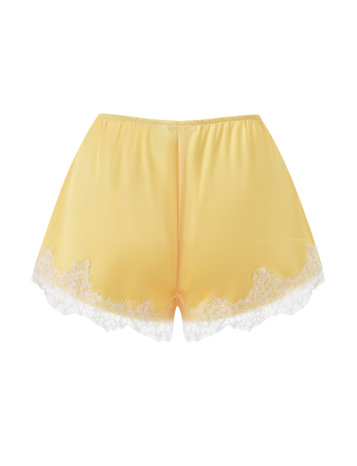 The SOLSTICE SHORT - YELLOW by TIGERMIST features luxe yellow satin with elegant white lace trim along the hem, displayed against a crisp white background.