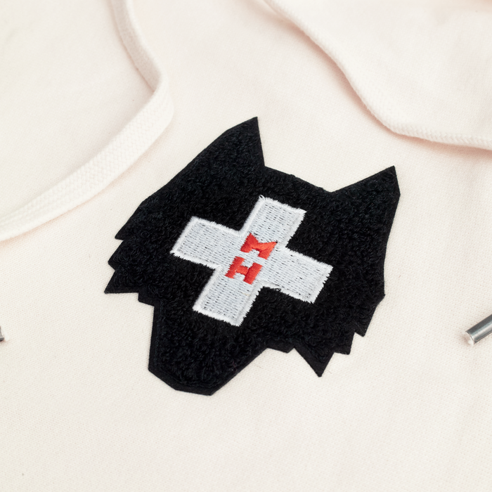 Morgan Hoffmann Foundation Wolf Embroidered Logo Close-Up on Stone Fleece Hoodie | Greyson Clothiers