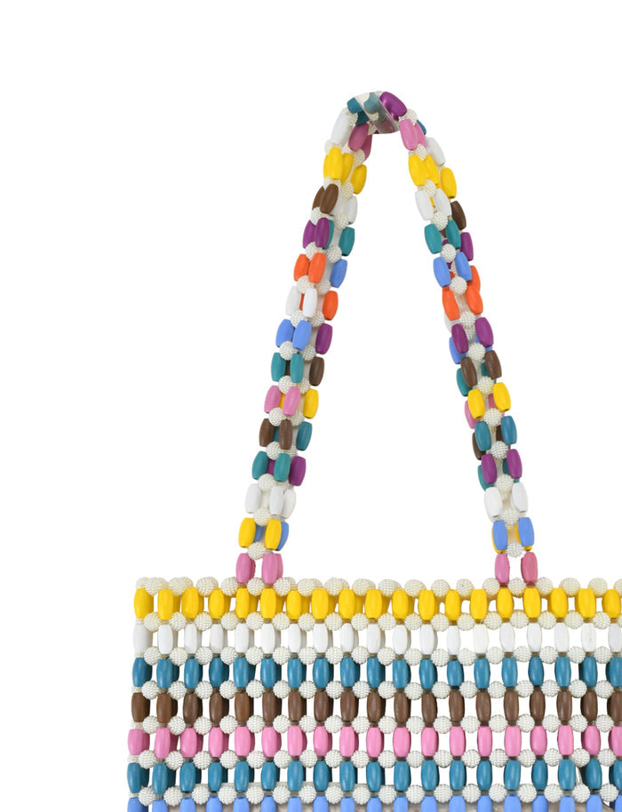 The STORMY BAG - STRIPE by TIGERMIST is a chic wooden bead bag featuring vibrant rows of yellow, white, brown, pink, and blue beads. Its handle showcases a colorful rainbow pattern, adding a unique textured touch to this stylish accessory.