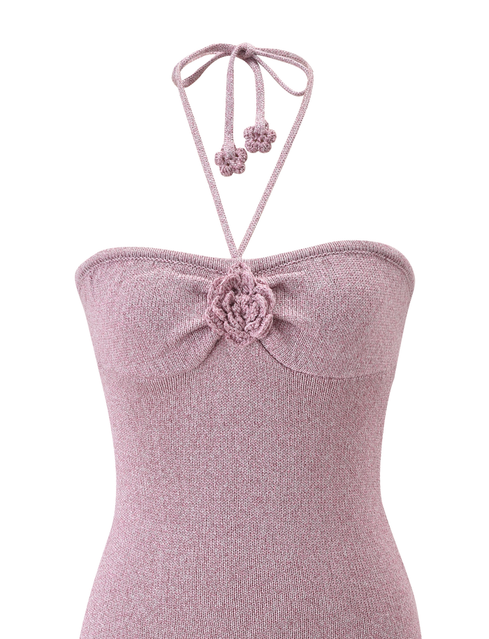 A close-up of the TIGERMIST SUNIA DRESS in baby pink, a knit dress with a sweetheart neckline, crochet flower at the center, and neck ties adorned with matching flower accents.