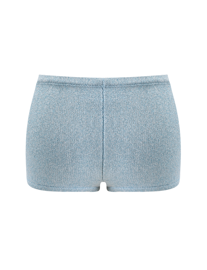 The SUNIA SHORT - BLUE by TIGERMIST is shown from the back, featuring a seamless waistband and soft, textured fabric in a light blue shade against a plain white background.