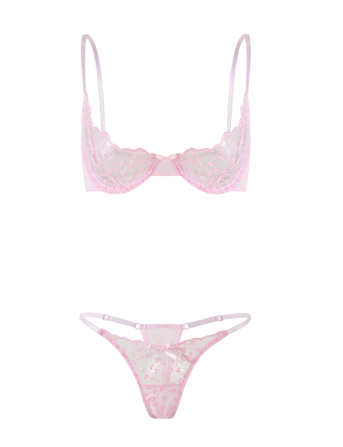 The TALIYAH SET - PINK by TIGERMIST is a baby pink lace lingerie set featuring a sheer, floral-embroidered bra with thin straps and a matching g-string with coordinating embroidery and delicate strap accents.