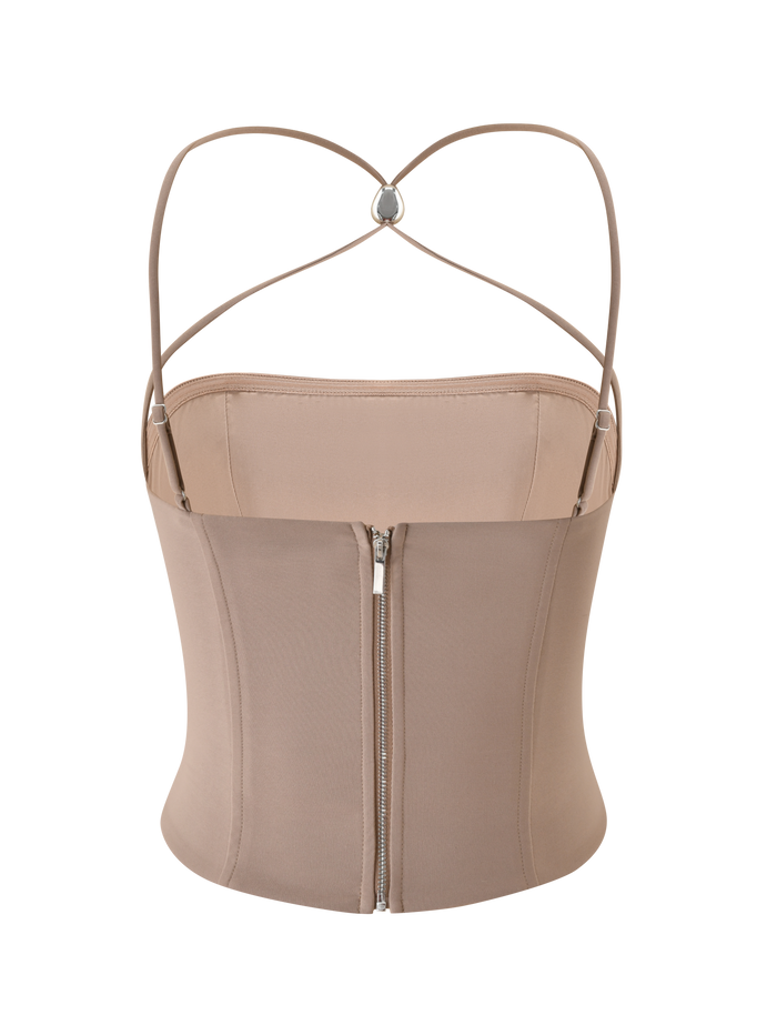 The TAMORA CORSET TOP - TAUPE by TIGERMIST is a 90's inspired corset with thin, adjustable X-back straps and a visible silver center zipper.