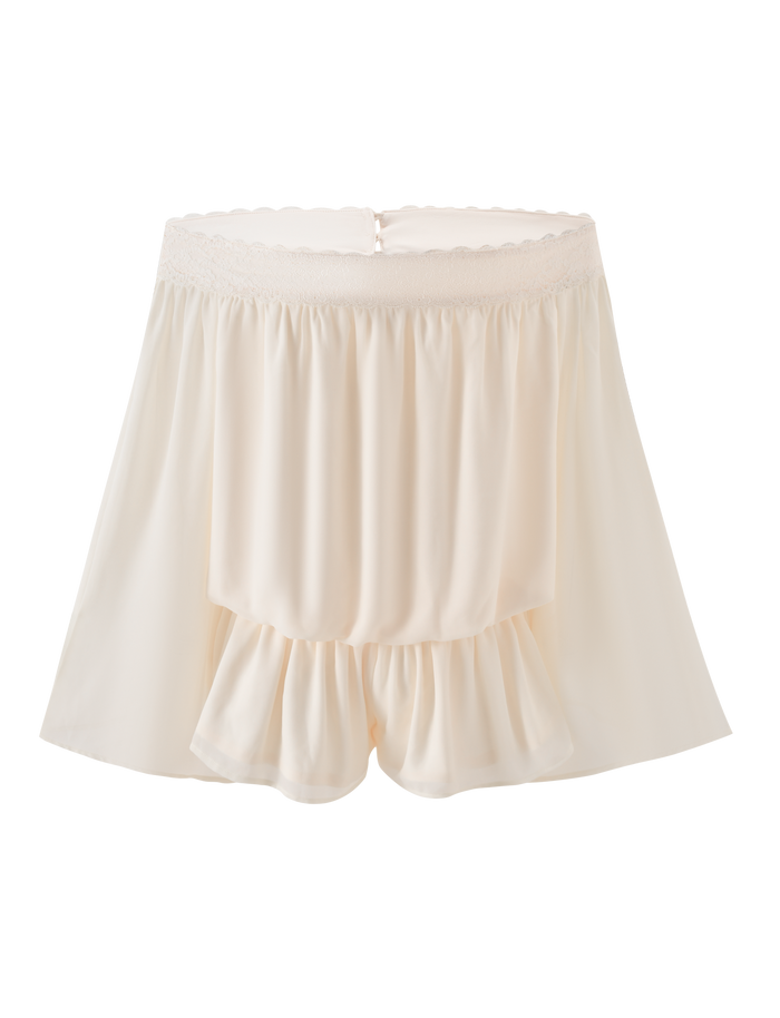 The TIGERMIST TESSIE PLAYSUIT in ivory features a cream hue, flowy ruffles, lace trim, and an elastic waistband. Made from lightweight, soft fabric, it’s perfect for loungewear or sleepwear.
