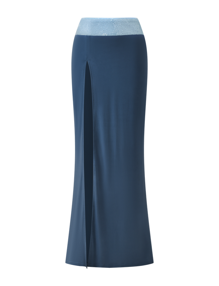 The TIGERMIST THARA MAXI SKIRT in slate blue features a thigh-high slit, sparkling sequin waistband, and ankle-length design, shown against a plain white background.