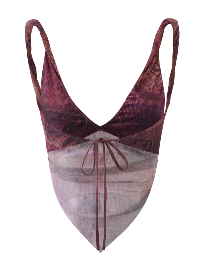 The THEO TOP - PLUM BUTTERFLY PAISLEY by TIGERMIST features a sleeveless, V-neck design with thin straps, front drawstring tie, butterfly paisley print in purple and pink, and a sheer layered handkerchief hem.