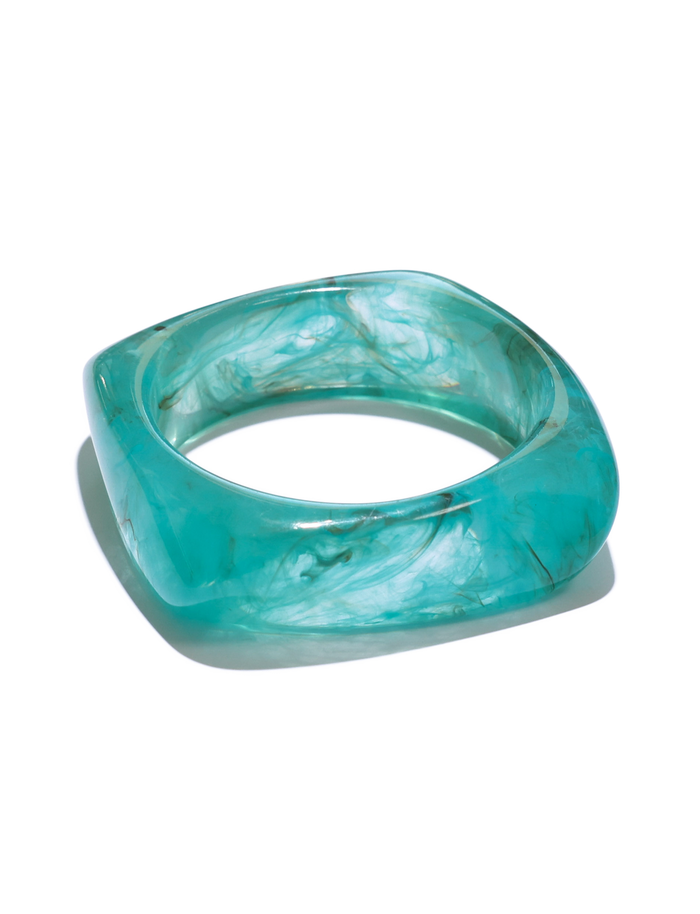 The TIA CHUNKY 2PC RESIN BANGLE SET by TIGERMIST features geometric, square-shaped bangles in cream and blue resin with a marble-like, swirling finish, shown on a white background.