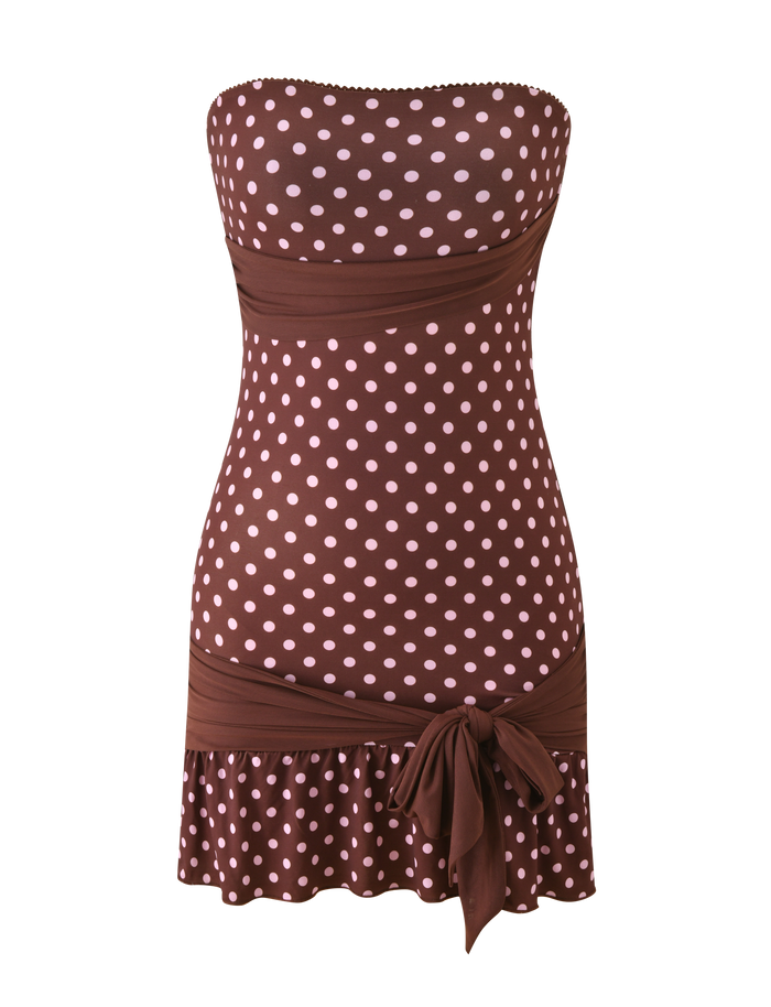 The TOVE MINI DRESS - CHOCOLATE POLKA DOT by TIGERMIST is a strapless mini dress with pink polka dots, a fitted waist, sweetheart neckline, bow at the hip, and playful ruffle hem.