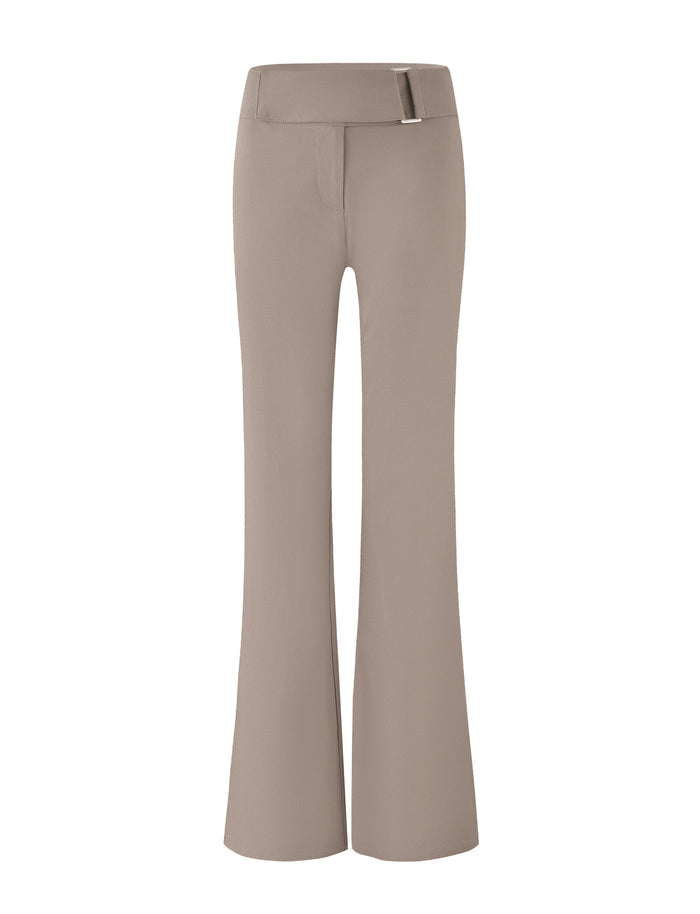 A pair of brown and tan high-waisted trousers with flared legs and a streamlined look. The VESPER PANT from TIGERMIST features a wide waistband with a small, decorative metal buckle on the side.