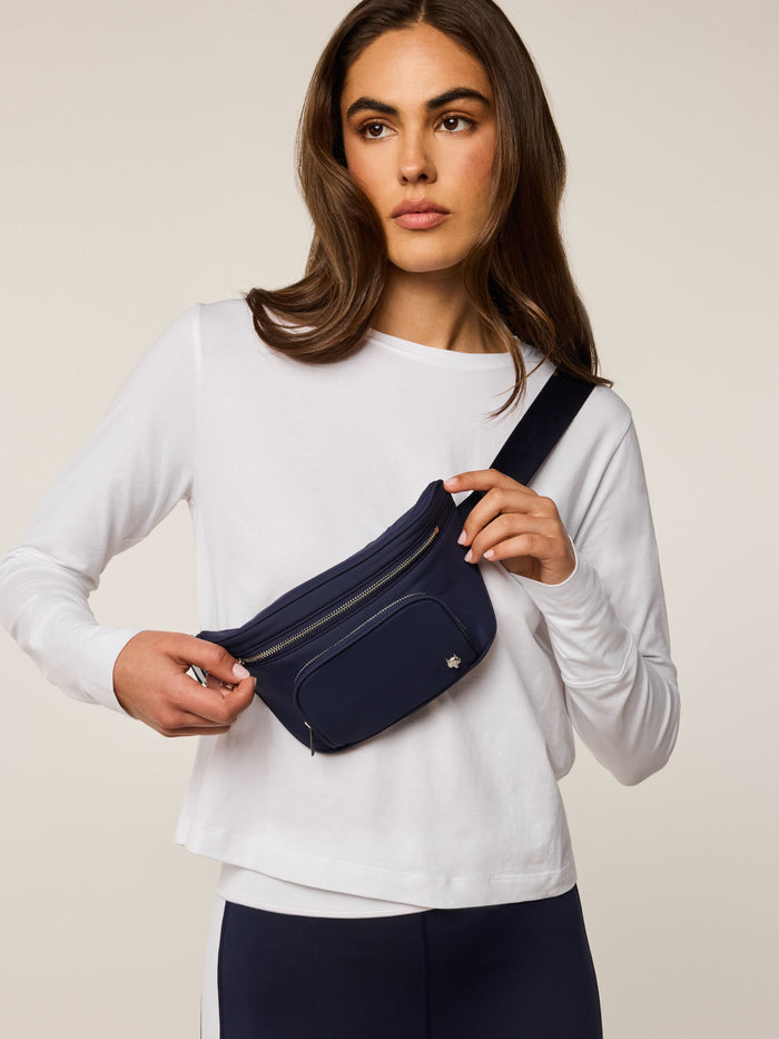 Maltese Blue Wind Cross Body Pack worn as crossbody sling, silver zippers, wolf emblem - On Model Front | Greyson Clothiers