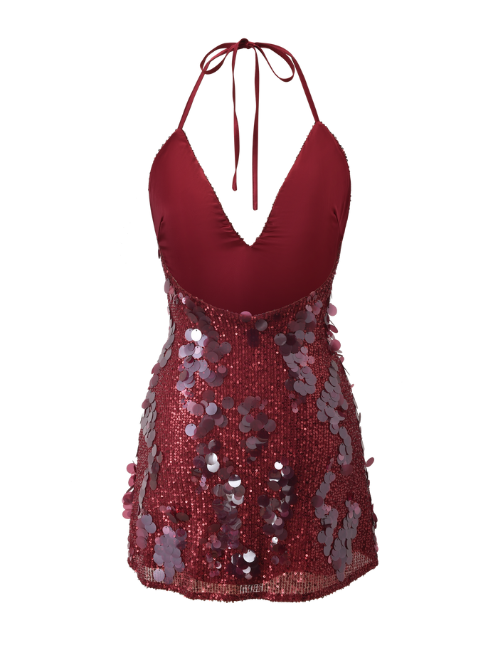 The ZANA MINI DRESS by TIGERMIST is a red halter neck mini dress featuring a low cut V neckline, sparkling sequins, and large decorative paillettes on the skirt for a glamorous, festive look.