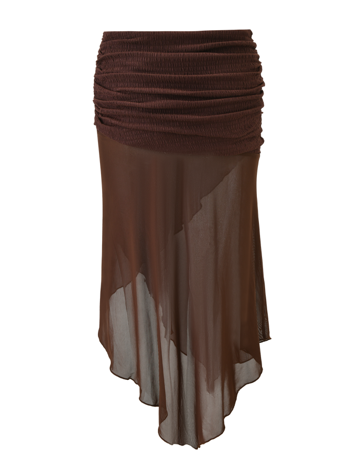 The TIGERMIST ZINNIA MIDI SKIRT in chocolate features a lightweight, semi-transparent fabric, a textured stretch knit waistband, and an asymmetrical hem for effortless style.