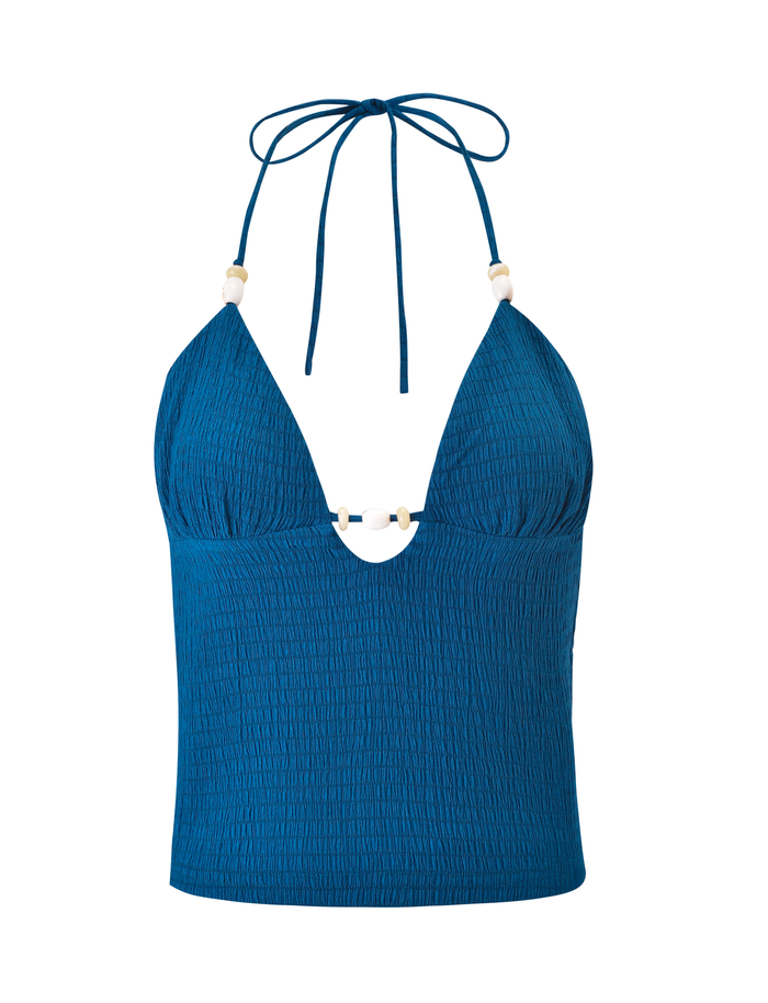 The ZINNIA TOP - BLUE by TIGERMIST features a textured bodycon fit, deep V-neckline, white bead details, and halter tie straps.