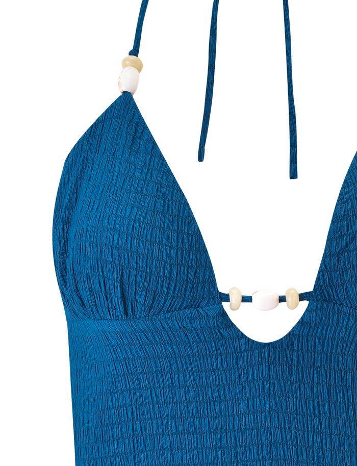 Close-up of the TIGERMIST ZINNIA TOP - BLUE, a halter bikini top with textured fabric and charming bead accents on the straps and center bust.