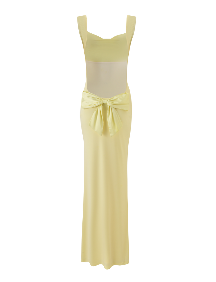 The TIGERMIST ZITA MAXI DRESS - LEMON is a sleeveless, floor-length pastel yellow dress with a square neckline and a large decorative waist bow, styled against a matching soft yellow background.