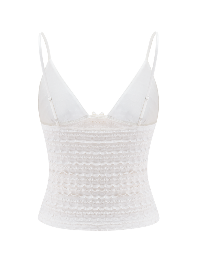 The ZORA TOP - CREAM by TIGERMIST features adjustable straps, a fitted ruched bodice, and sheer textured fabric with ruffle detailing—perfect for layering or wearing solo.